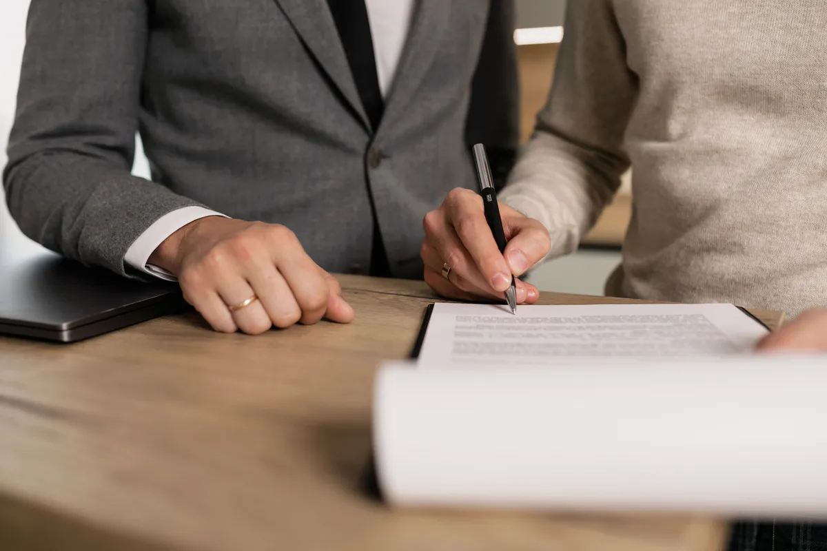 Signature d'un devis sur papier, stylo en main